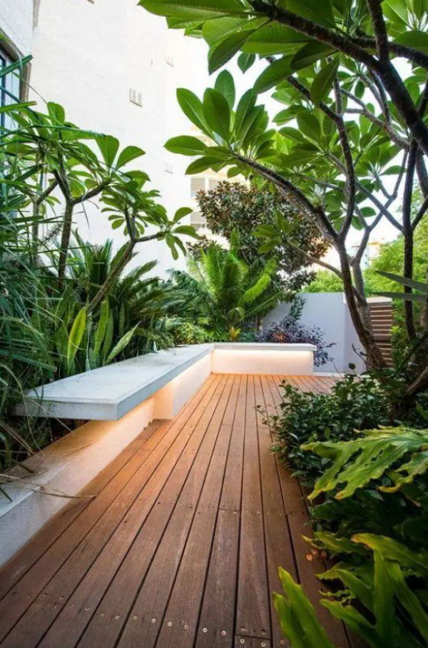 Taman minimalis modern dengan teras kayu dan tanaman pot